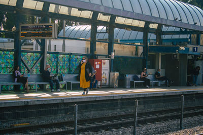 People walking on railroad station platform