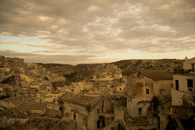 Townscape against cloudy sky during sunset