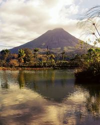 Scenic view of lake by mountains against sky