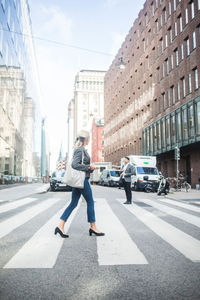 Businesswoman crossing road in city