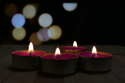 Close-up of illuminated candles on table in temple