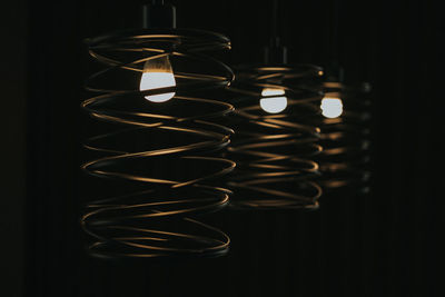 Close-up of illuminated lights hanging in darkroom