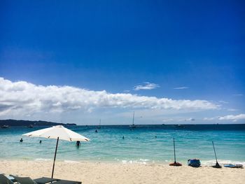 Scenic view of beach against blue sky