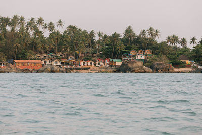 Scenic view of sea and buildings against clear sky