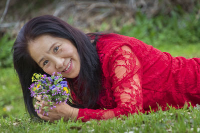 Portrait of smiling young woman lying on grass