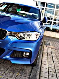 Close-up of blue car on street