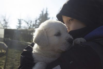 Close-up of child carrying white puppy