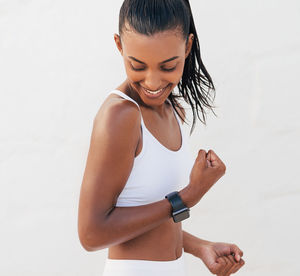 Side view of young woman suffering from mobile phone against white background