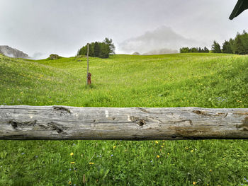 Wooden fence on field against sky
