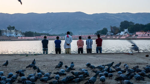 People on shore against sky