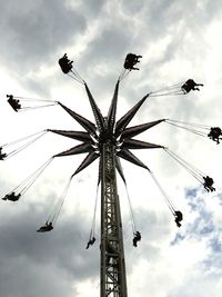 Low angle view of ferris wheel against cloudy sky