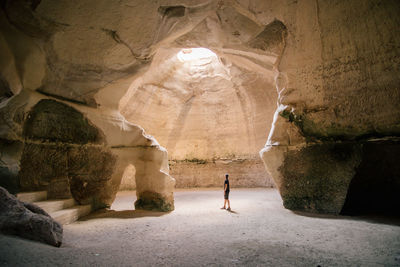 Rear view of man standing in cave