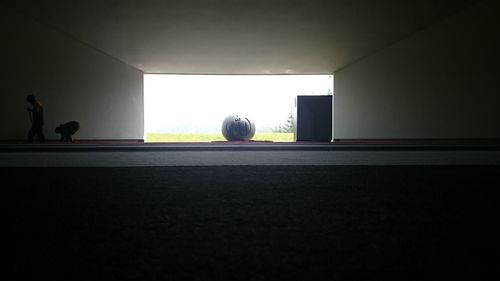 Silhouette people playing soccer ball on wall