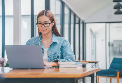 Young woman using laptop at table
