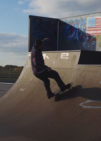 Man jumping on soccer field against sky