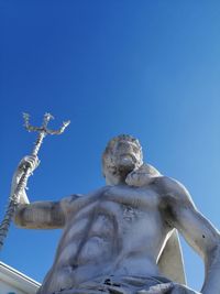 Low angle view of statue against blue sky