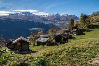 Scenic view of mountains by houses against sky