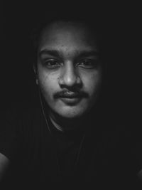 Close-up portrait of young man in darkroom