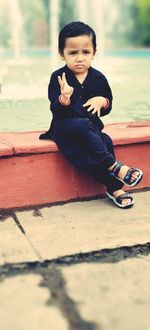 Portrait of boy sitting outdoors