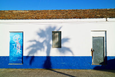 Closed door of house against blue sky