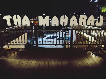 Illuminated bridge against buildings at night