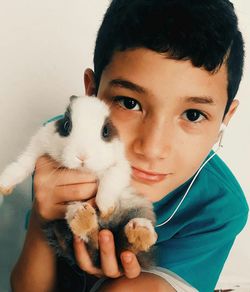 Close-up portrait of boy holding cute rabbit