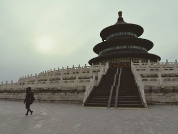 Rear view of woman walking in front of historical building