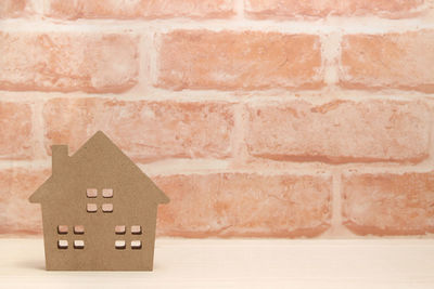 Close-up of toy against brick wall of building