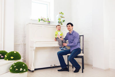 Full length of man and woman standing by potted plant