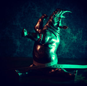 Statue against illuminated blue background