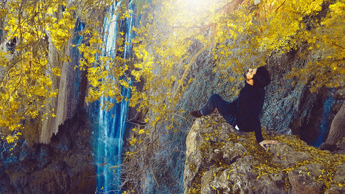 Man standing by rocks in forest