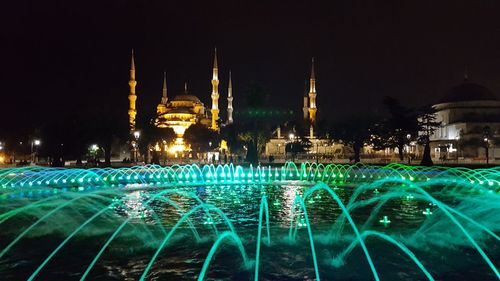 Illuminated temple against sky at night