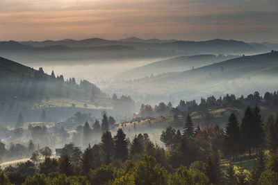 Panoramic view of trees and mountains against sky during sunset