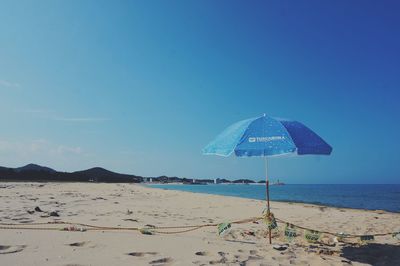 Scenic view of beach against blue sky