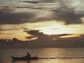 Scenic view of sea against cloudy sky at sunset