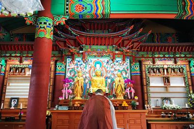 Rear view of a woman praying at buddha