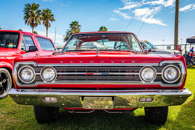 Red vintage car parked against sky