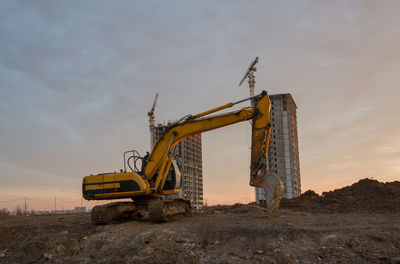 Large tracked excavator at construction site on the background sunset. backhoe dig the ground 