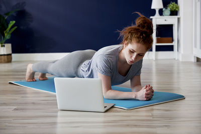 Full length of woman exercising at home