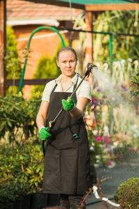 Portrait of a smiling young woman standing in greenhouse