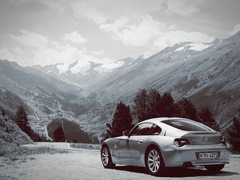 Car on snowcapped mountains against sky