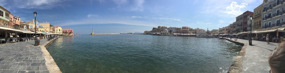 Panoramic view of buildings by sea against sky