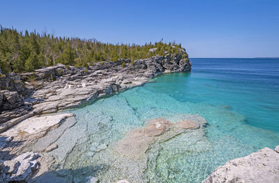 Clear waters in a gray cliffed cove at indian cove in bruce peninsula national park in ontario