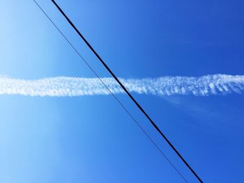 Low angle view of vapor trail against clear blue sky