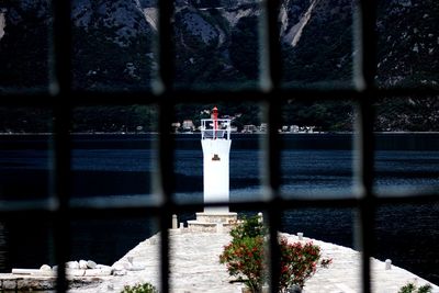 Lighthouse by sea against sky