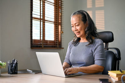 Young woman using laptop at table