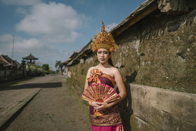 Portrait of woman standing against built structure