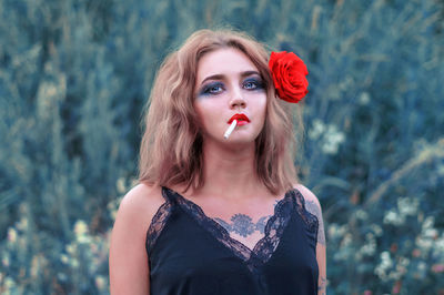 Beautiful young woman looking away while smoking cigarette