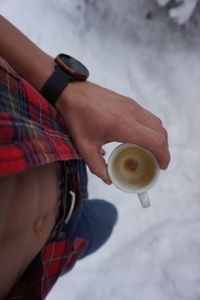 Midsection of woman holding coffee cup