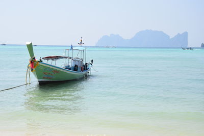 Boat moored in sea against clear sky